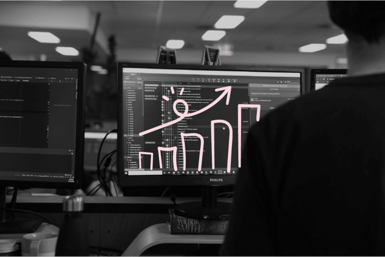 Black and white photo of a man looking at a computerscreen. Over the photo a pink graph has been drawn over it