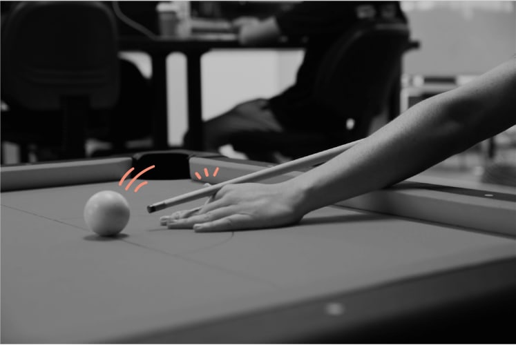 Photo of a close up of someones hands playing pool