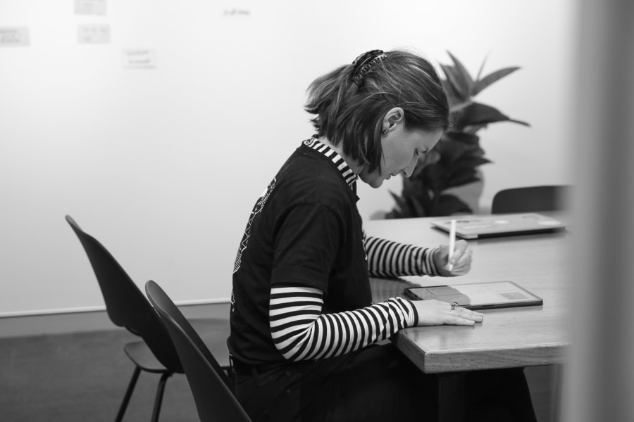 A photo of a woman drawign on an ipad