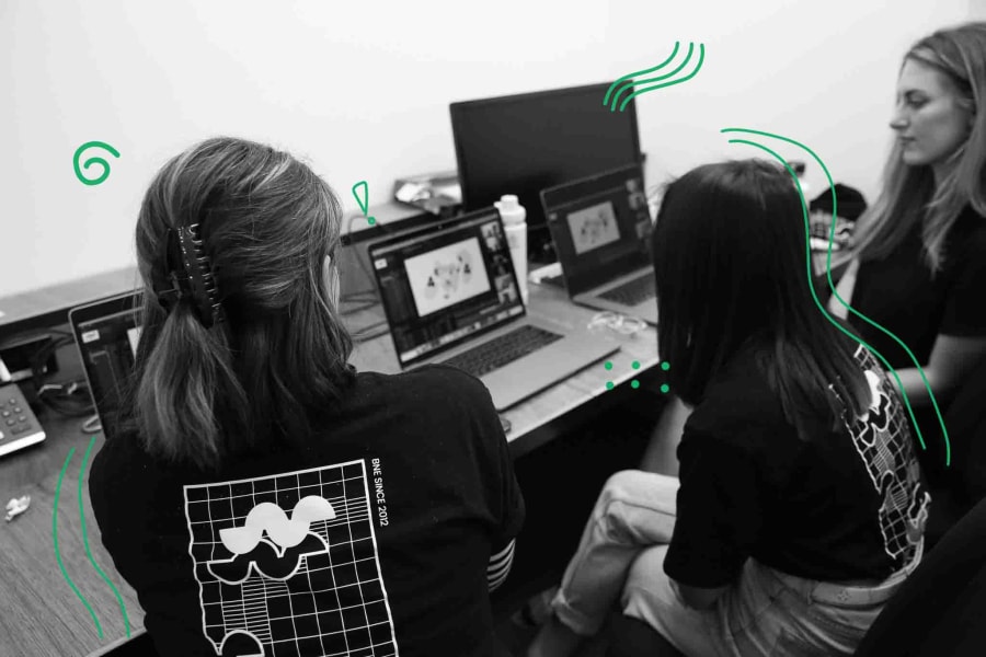 Three women sitting around a computer