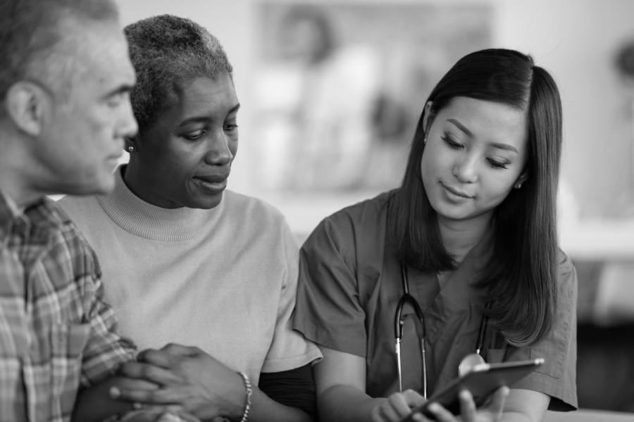 A nurse is talking to two people