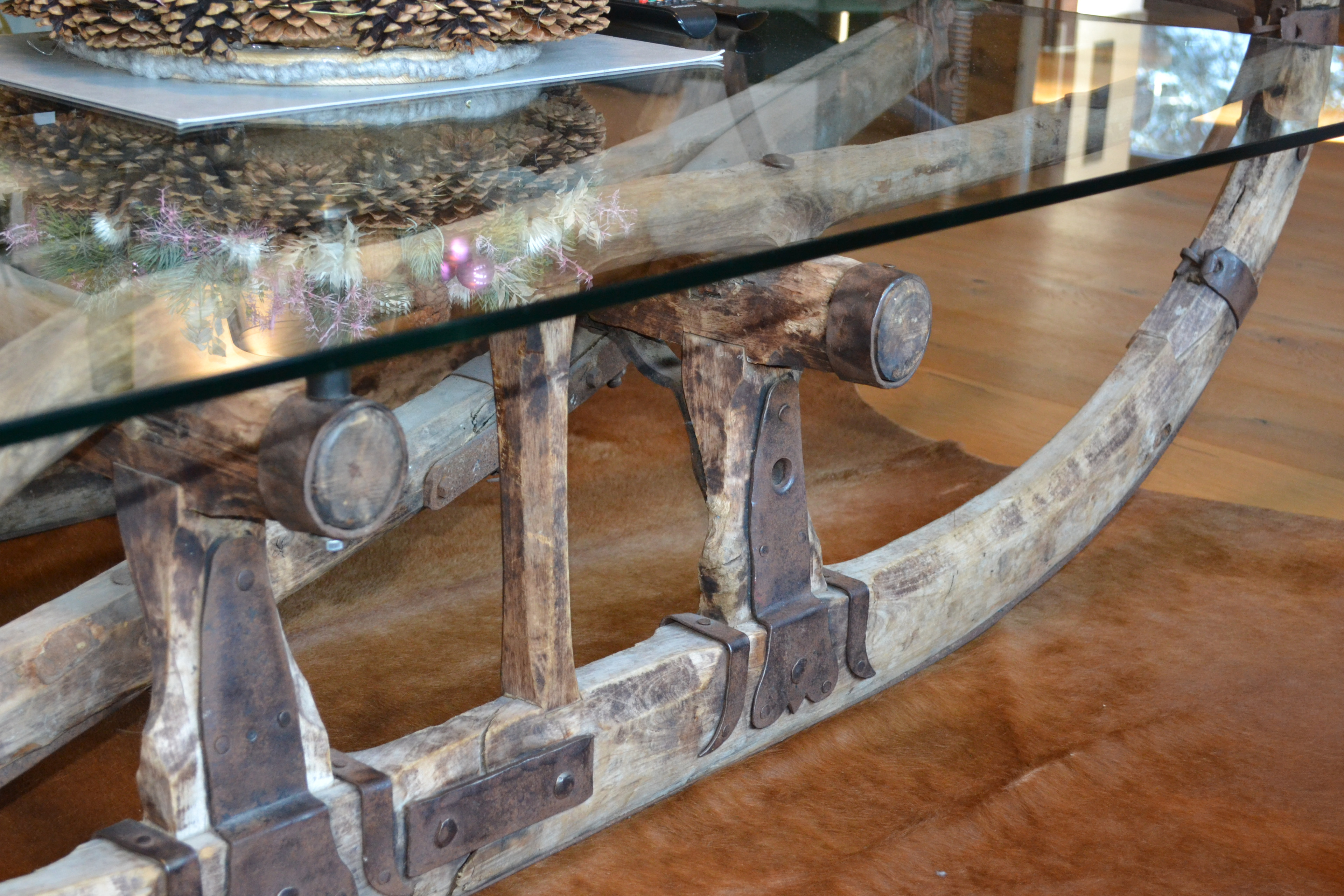 Glasplatte auf rustikalem Holzgestell im Schlitten-Design, warme alpine Einrichtung