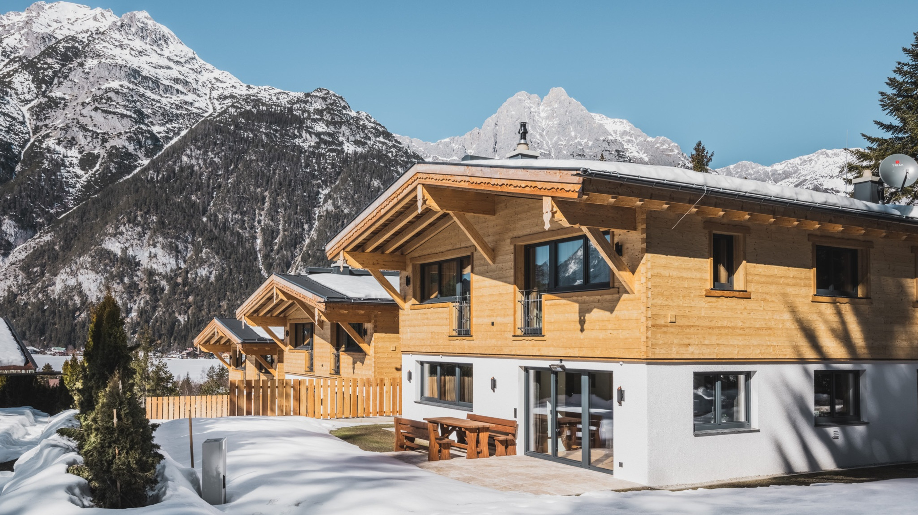 Winter view of the Wilderer Chalets in Leutasch – snow-covered luxury cabins