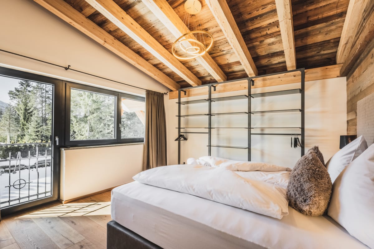 Ložnice 1: postel boxspring, teplé dřevěné tóny, klidná atmosféra