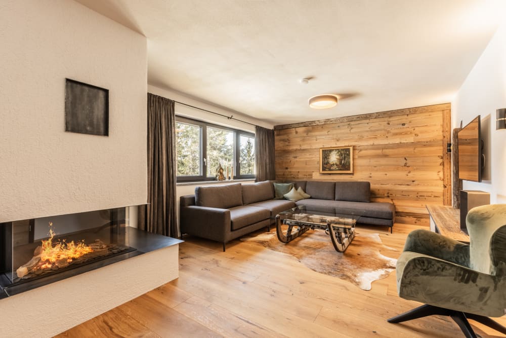 Wohnbereich der Wilderer Chalets mit Holz und Sitzgelegenheiten