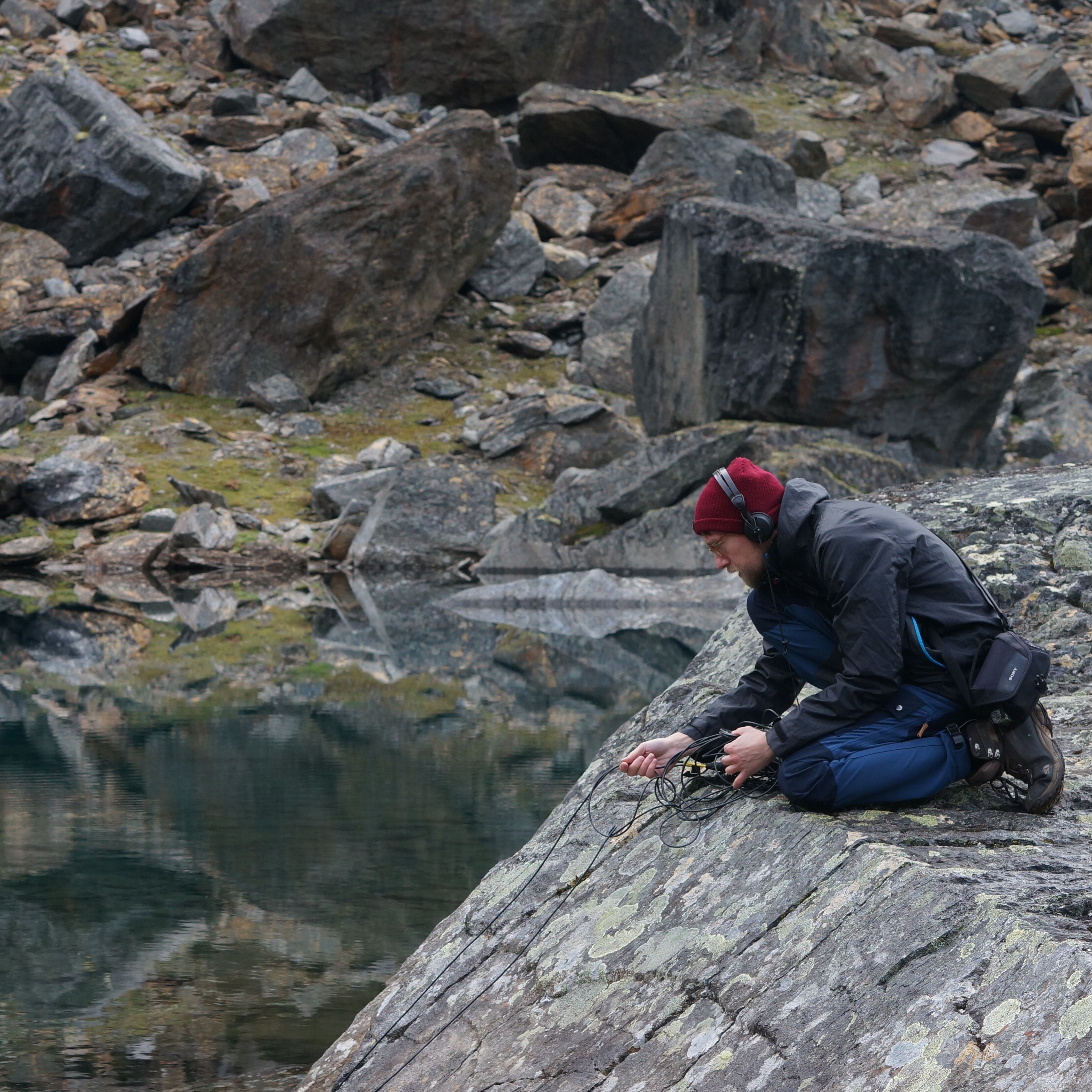 Jacek Smolicki recording sound on a boulder