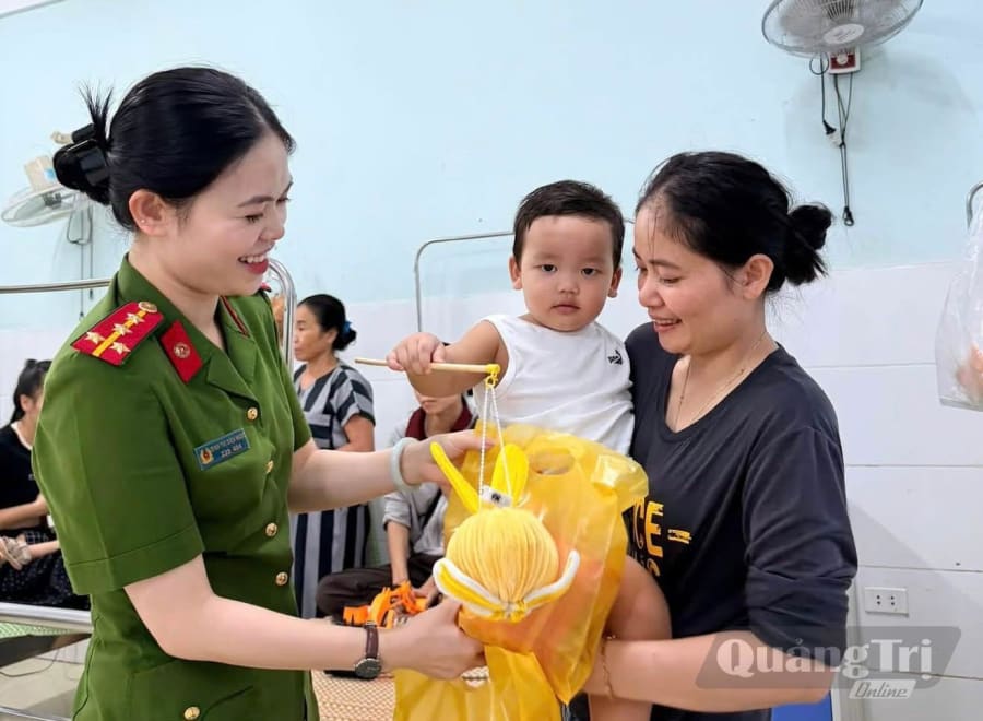 Cán bộ Công an xã Minh Hóa trao quà Trung thu, động viên bệnh nhi đang điều trị tại Bệnh viện đa khoa Minh Hóa - Ảnh: M.H