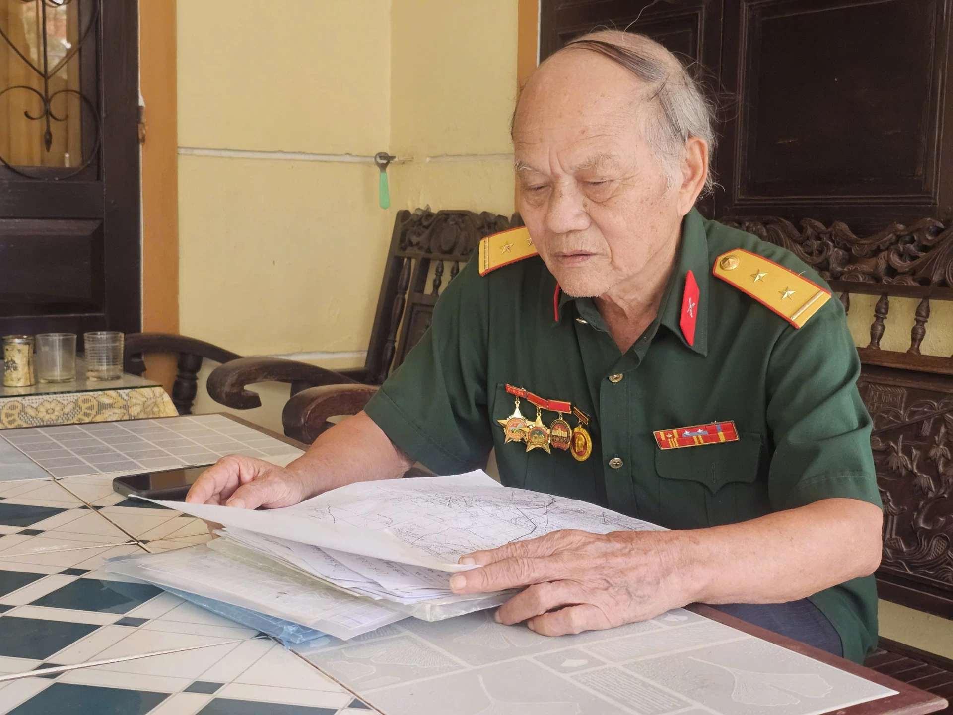 CCB Nguyễn Thanh Bình trân trọng lưu giữ tài liệu về đồng đội như báu vật vô giá - Ảnh: N.P
