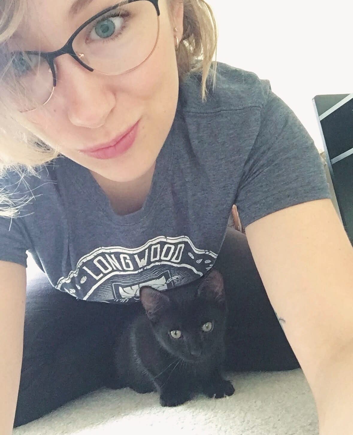 Charlie looking at the camera with a black kitten sitting in her lap