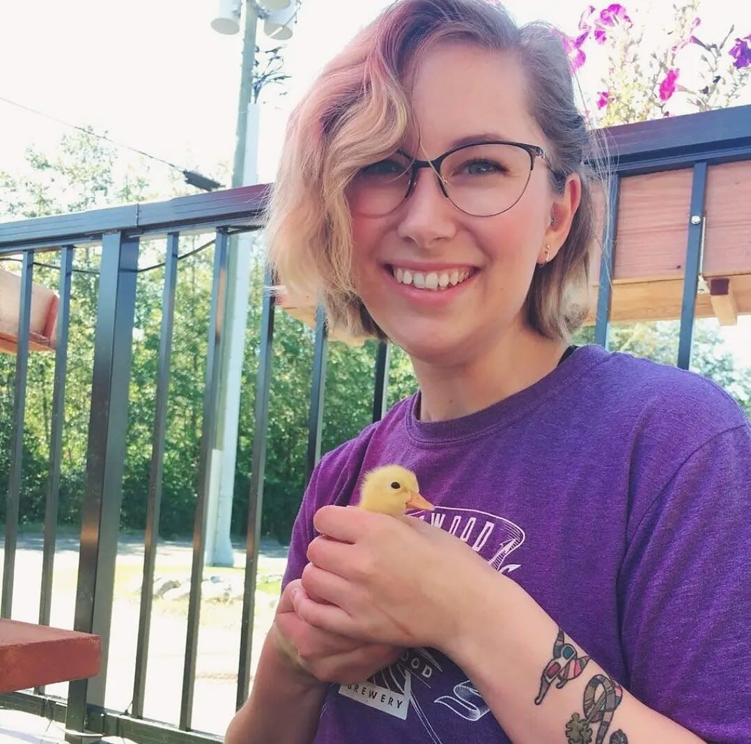 Charlie on a sunny patio holding a small yellow duckling