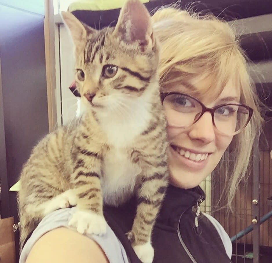 Charlie smiling with a tabby kitten standing on her shoulder