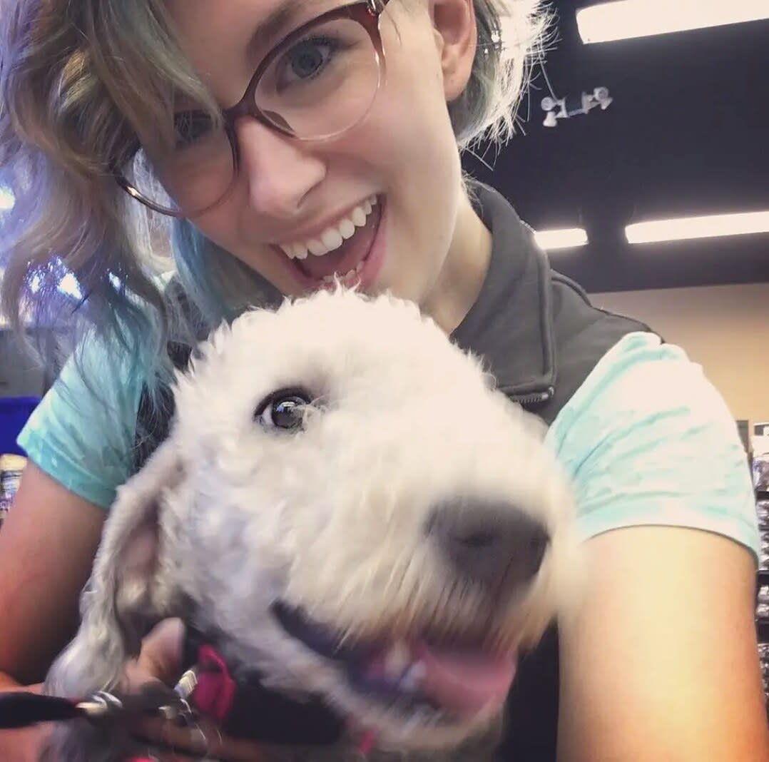 Charlie laughing while hugging a fluffy white dog with its tongue out