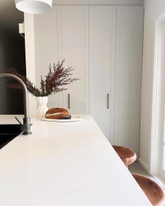 Ivanhoe Melbourne Kitchen renovation. White finishes with polished wooden stools and ornaments