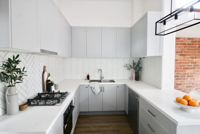 Brunswick, Melbourne Kitchen renovation. White kitchen with hanging frame lights, angled tiling and a wooden floor finish