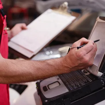 Homme travaillant sur écran tactile pour effectuer une inspection d’un inventaire d’un entrepôt.