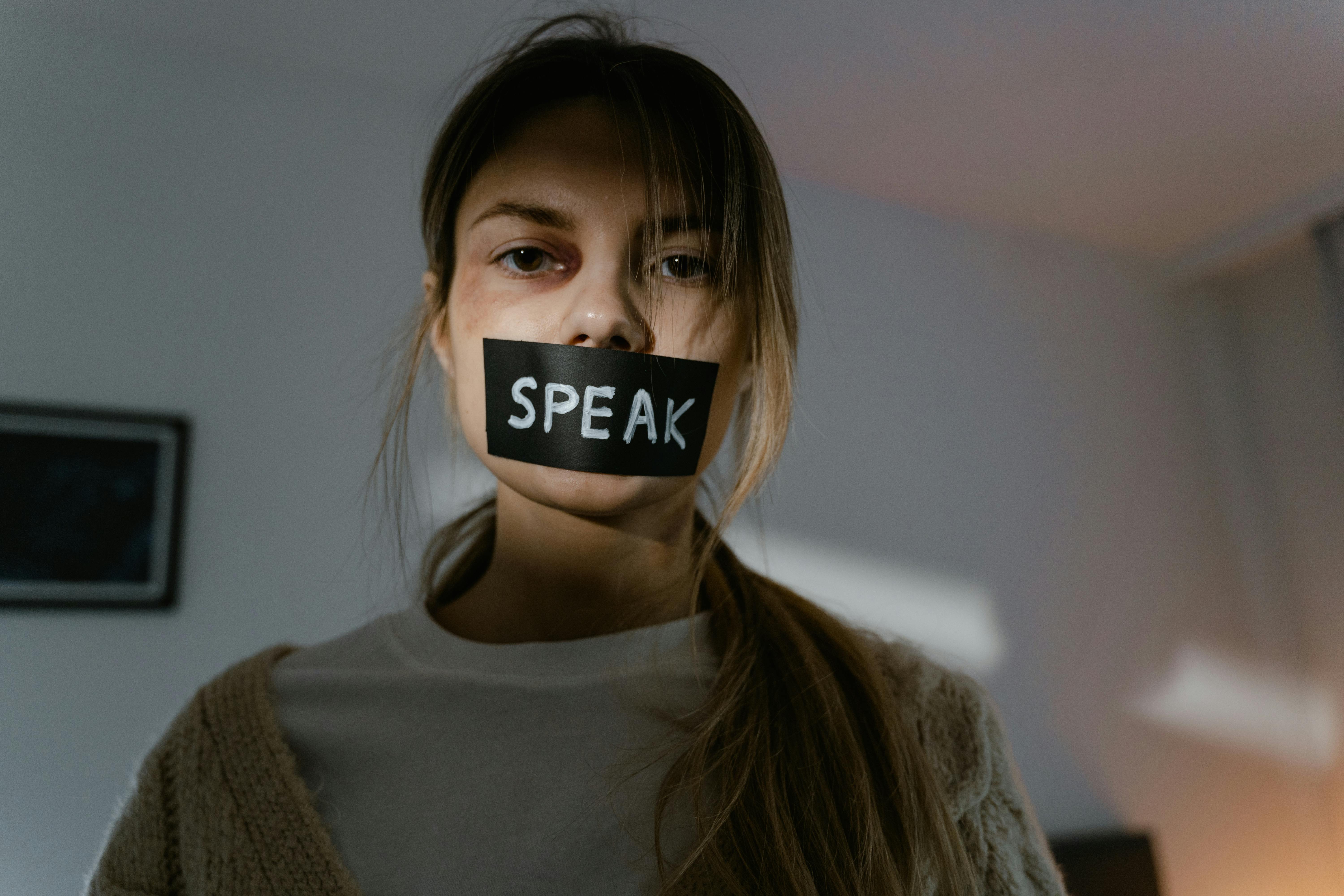 Woman with a tape on her mouth.