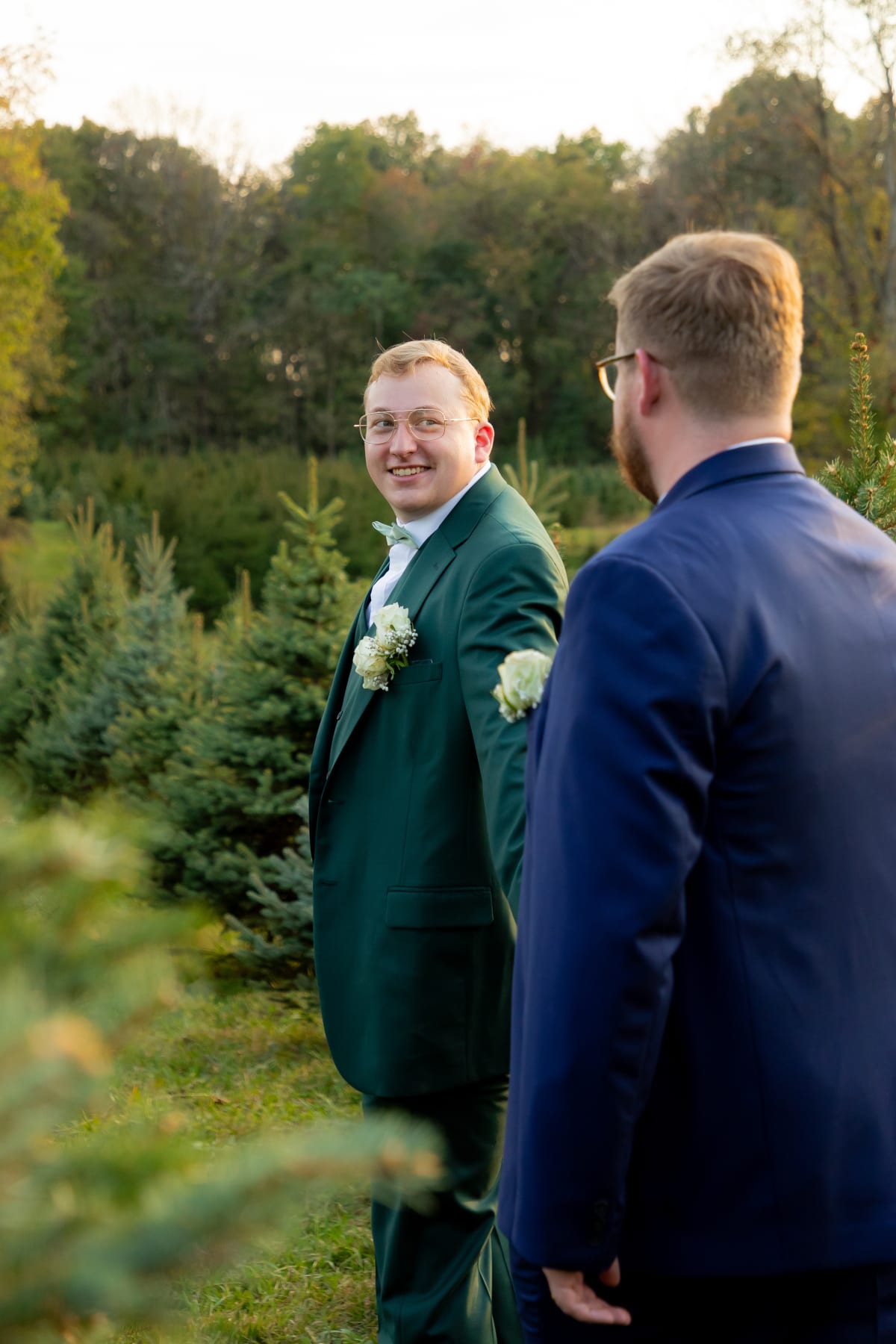 Two grooms sharing a joyful moment at their Christmas tree farm microwedding in Virginia