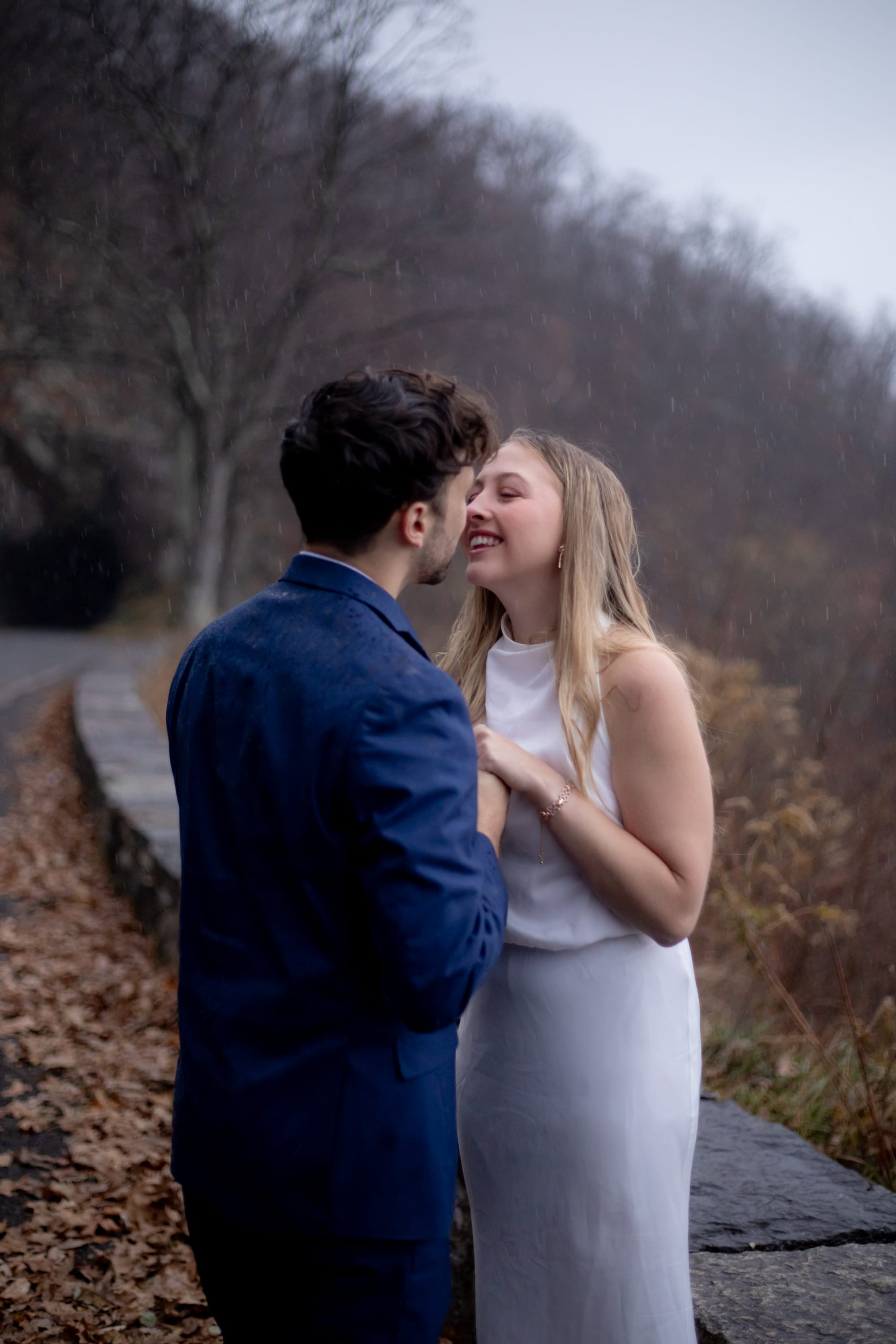 Couple laughing together in the rain on Skyline Drive, Shenandoah National Park, rain visible falling around them