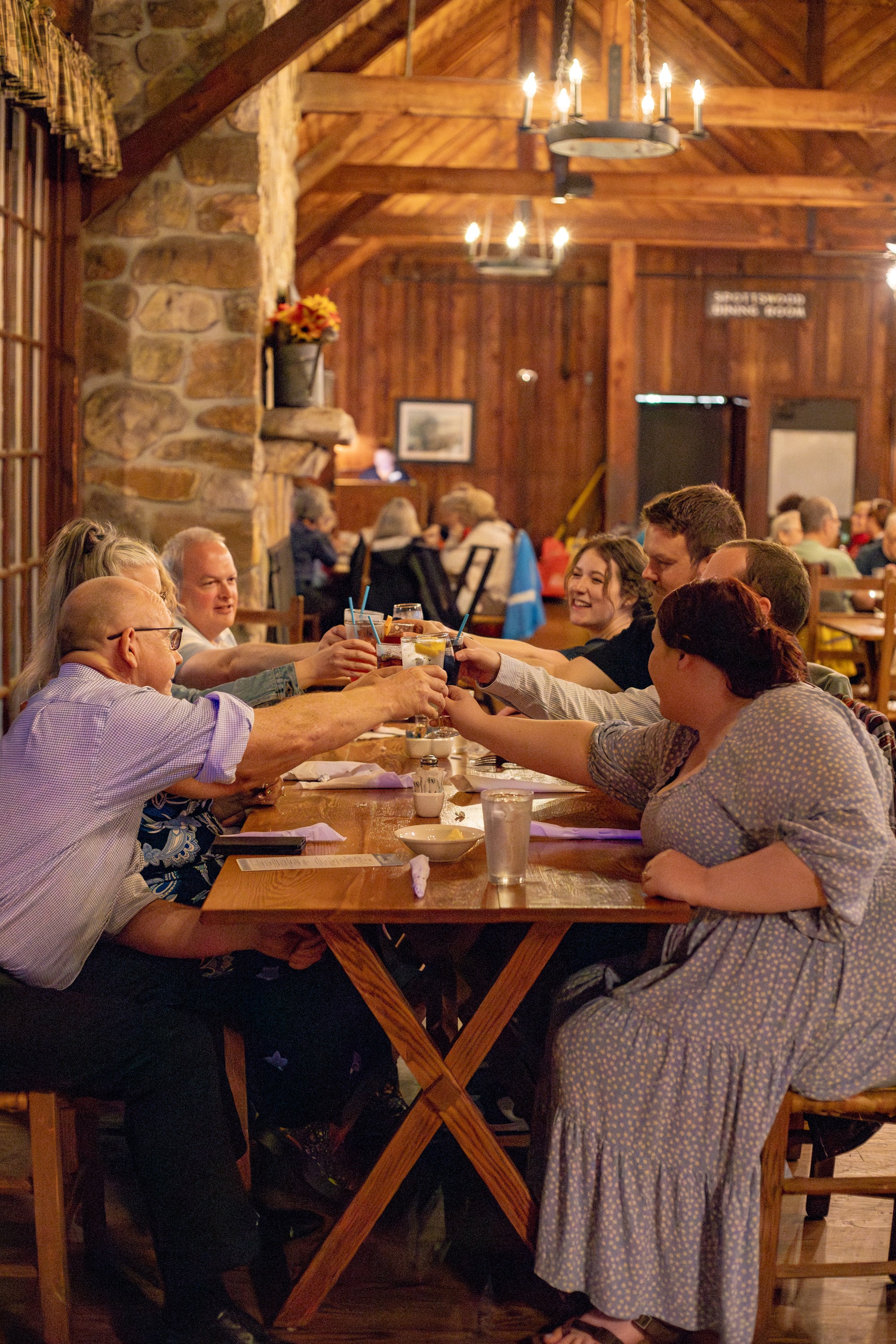 Group of diners raising their glasses in a toast inside the rustic Spottswood Dining Room at Big Meadows Lodge, Shenandoah National Park