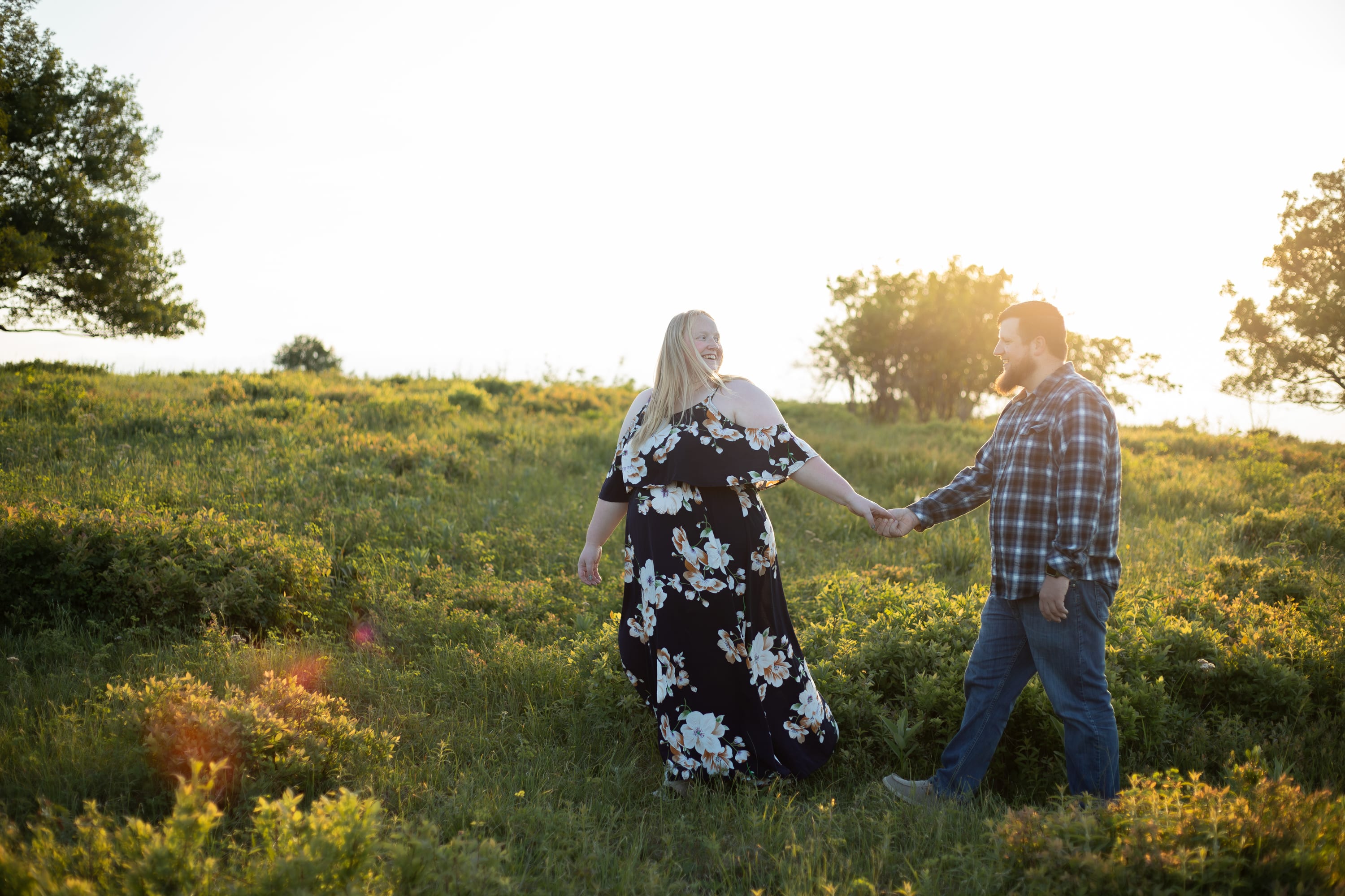couple walking hand in hand through Big Meadows in Shenandoah National Park during golden hour in summer