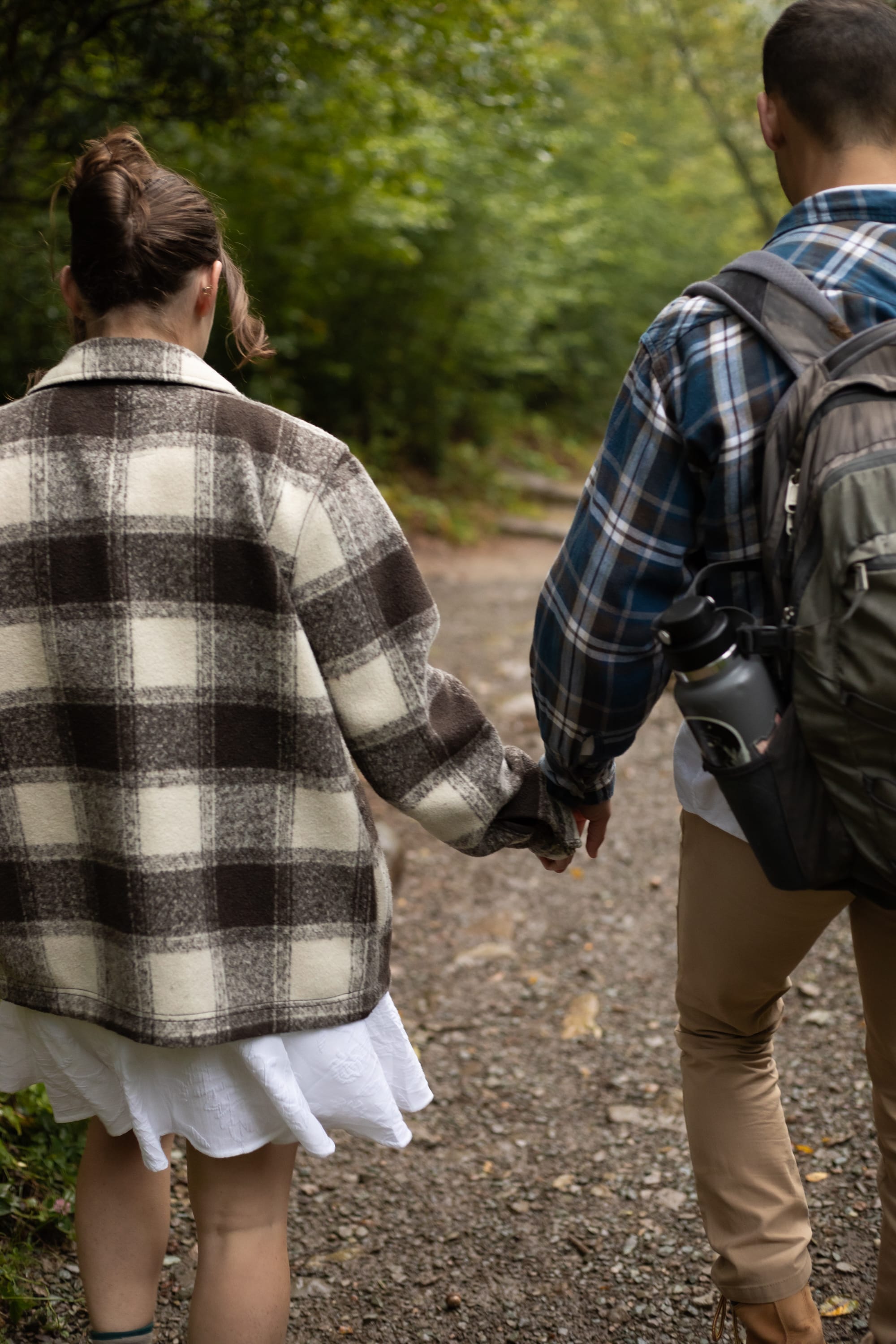 couple holding hands walking down a forest trail during their Shenandoah National Park elopement