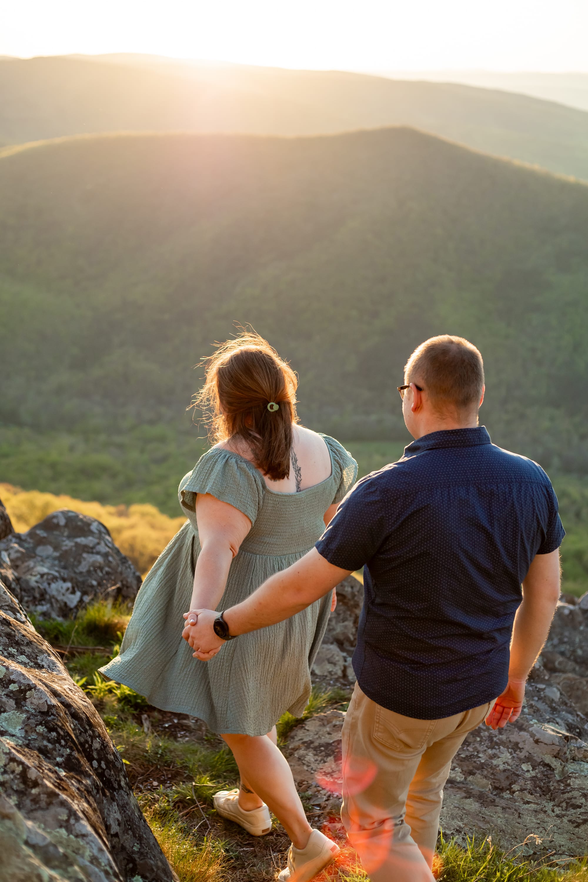 Couple on the side of Raven's Roost Overlook in golden hour light, Blue Ridge Parkway, Virginia