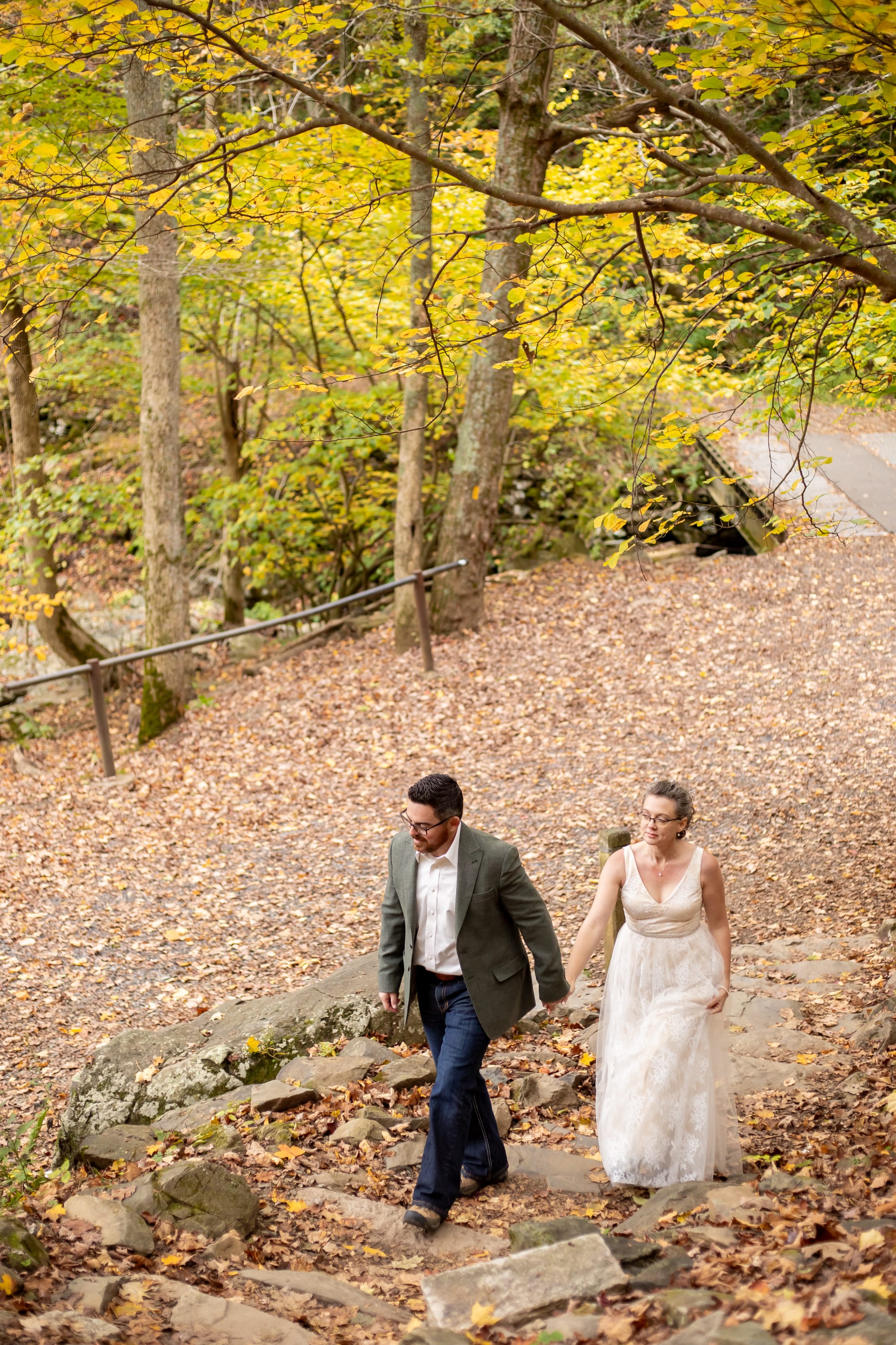 Couple walking up a trail near Rose River Falls during peak fall foliage in Shenandoah National Park, Virginia