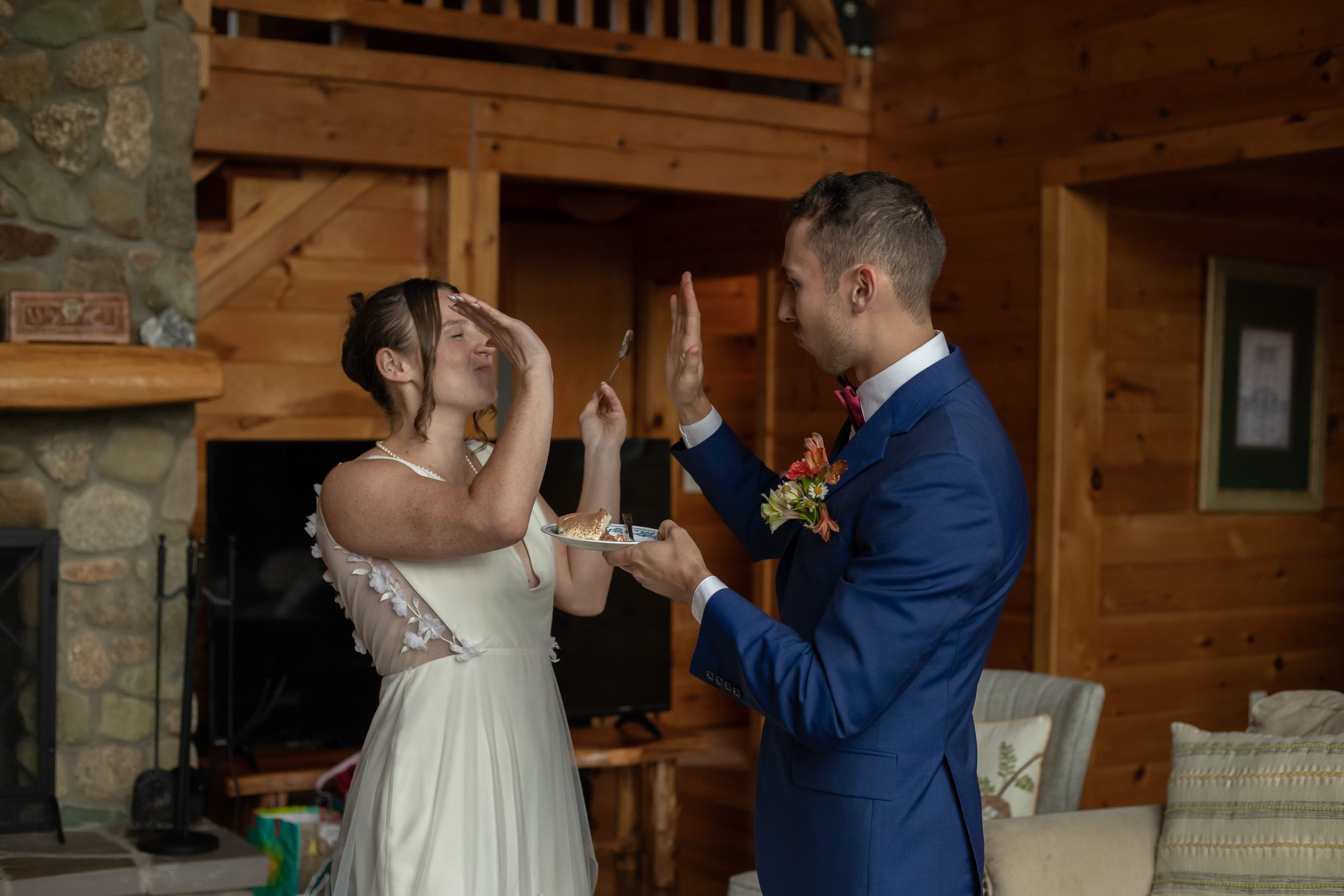Couple laughing during cake cutting inside a cabin at their Shenandoah elopement celebration