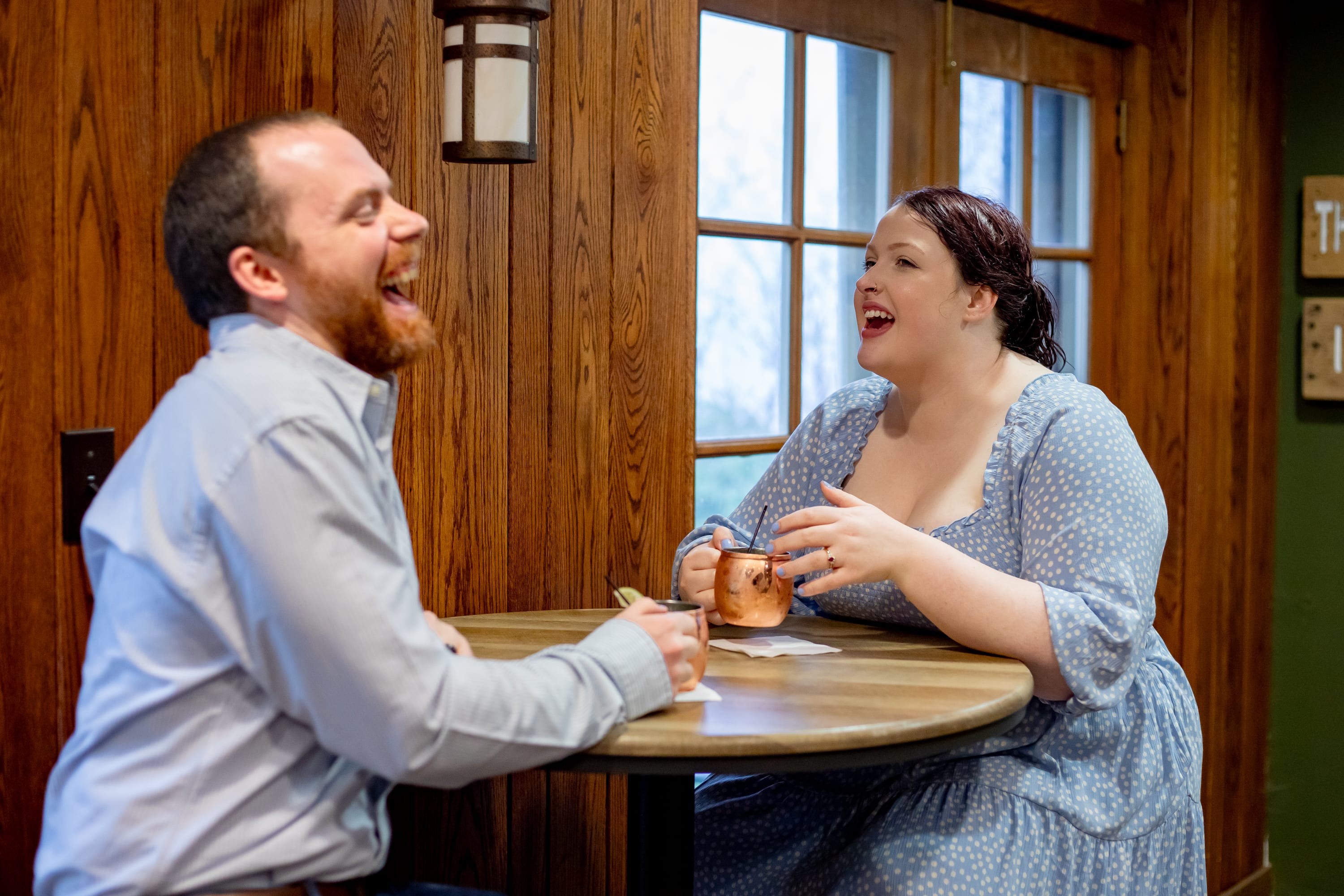 Couple laughing together over cocktails at the lodge taproom after their Shenandoah elopement