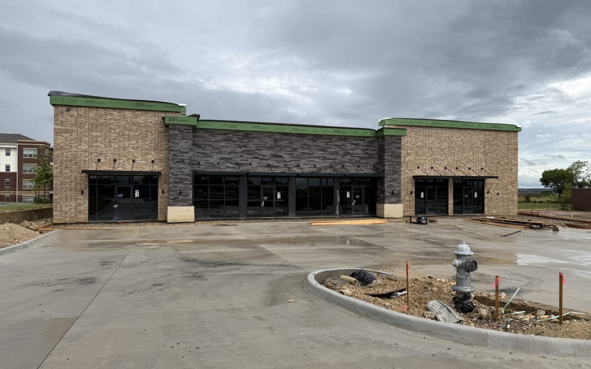Ashton Gray building with parking lot paved, June 14, 2026