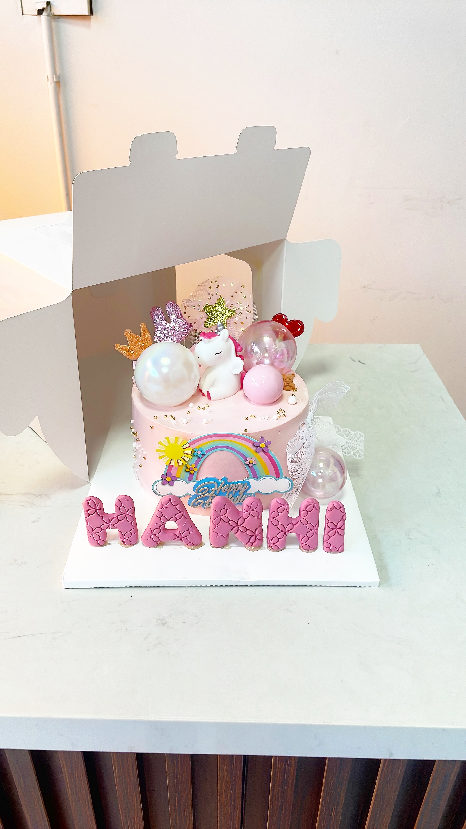 Bánh unicorn cầu vồng hồng nhạt tên bé