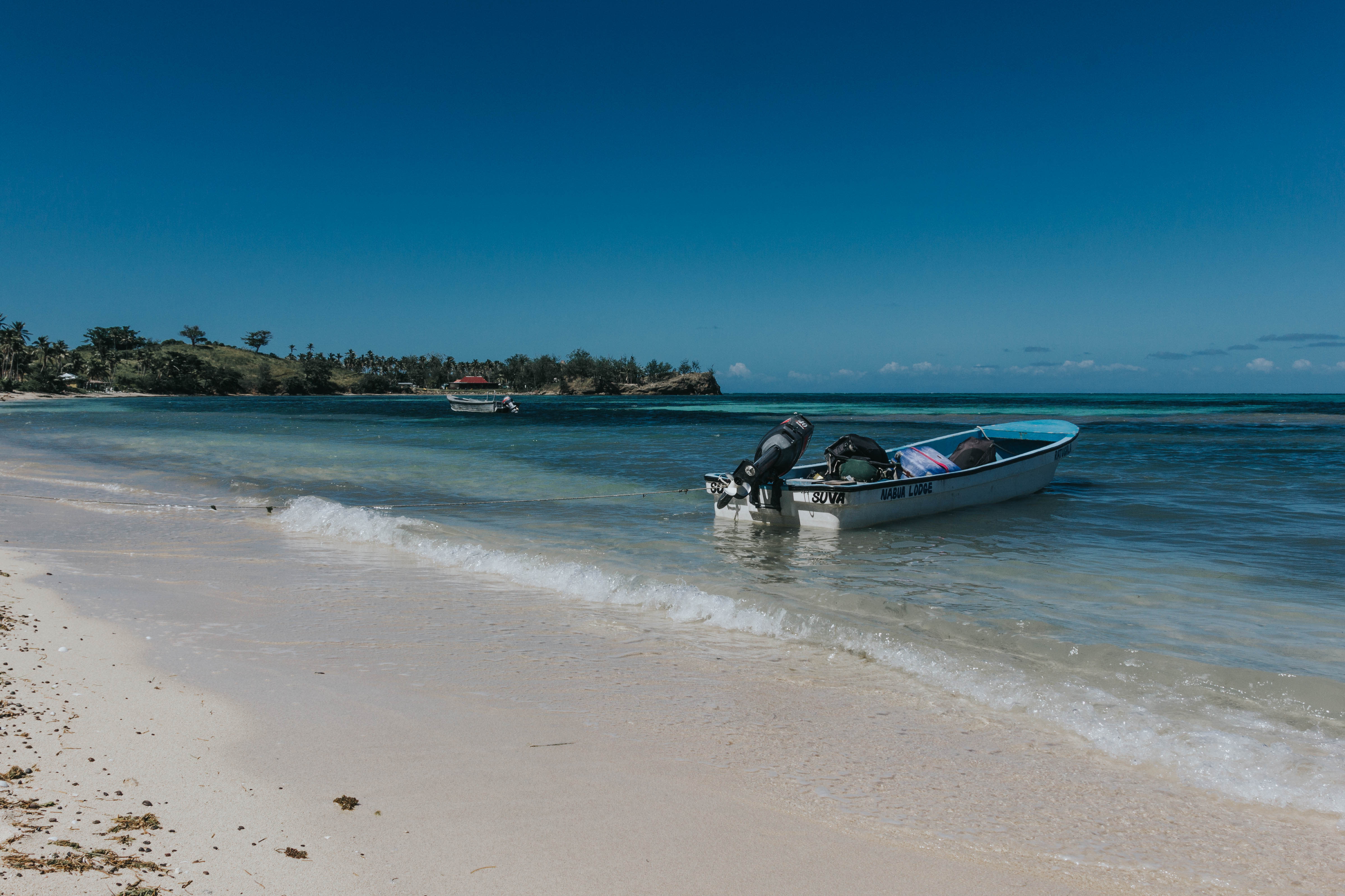 A beach with boats in the sea