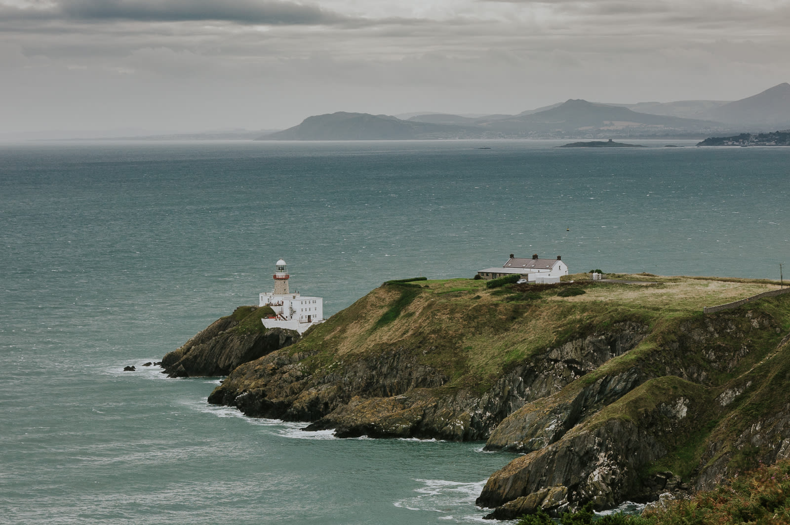 Lighthouse on peninsula surrounded by sea