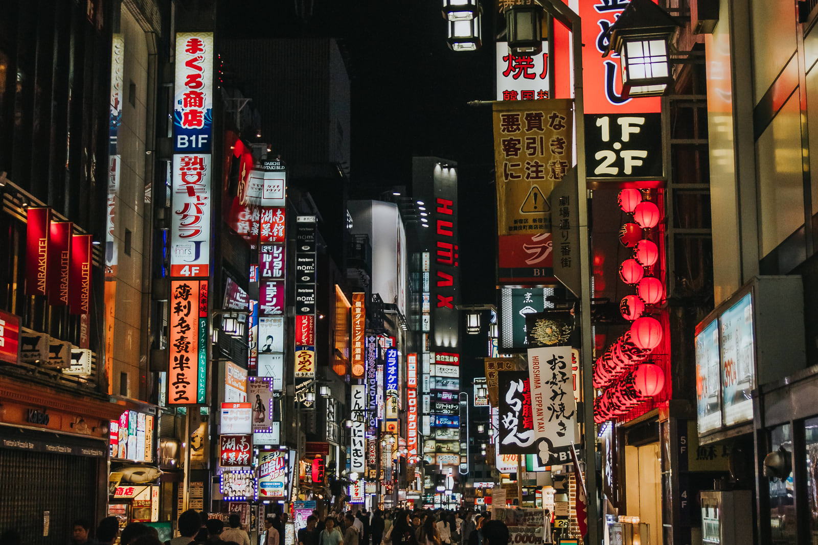 Busy Shinjuku street with signs lit up at night