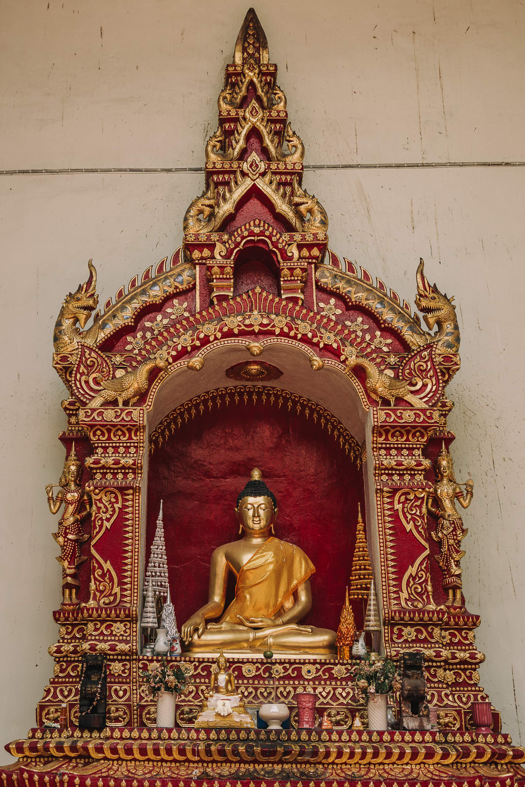 Shrine on a wall with gold Buddha