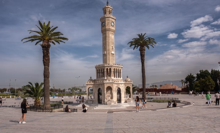 Historic clock tower among palm trees at Konak Square in Izmir
