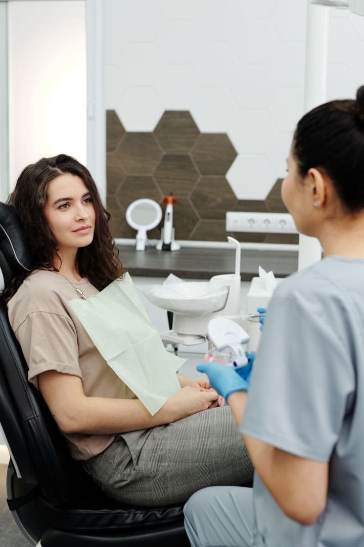 Patient speaking with a dentist during a routine dental review.