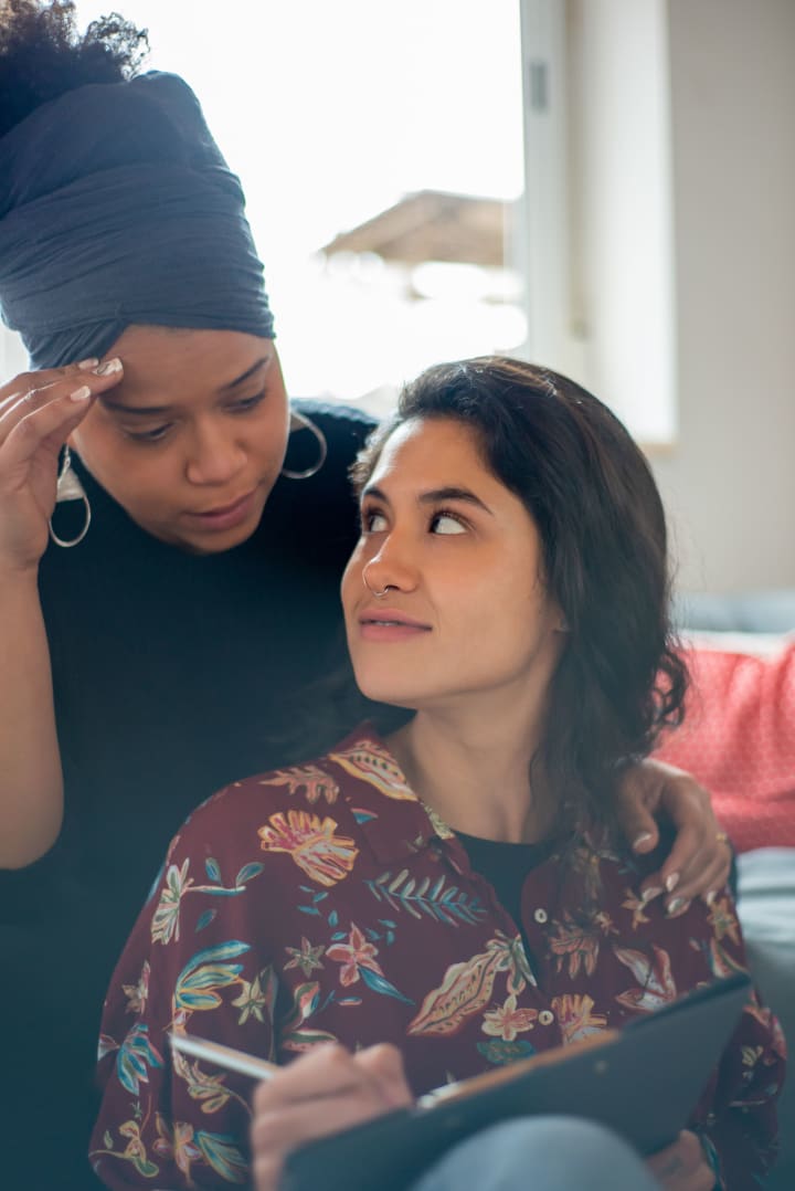 Two adult women planning together in a comfortable indoor setting.