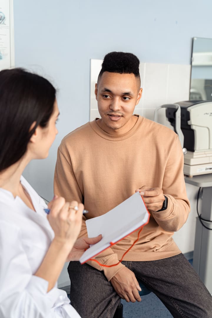 Adult discussing health information with a healthcare professional in a consultation room.