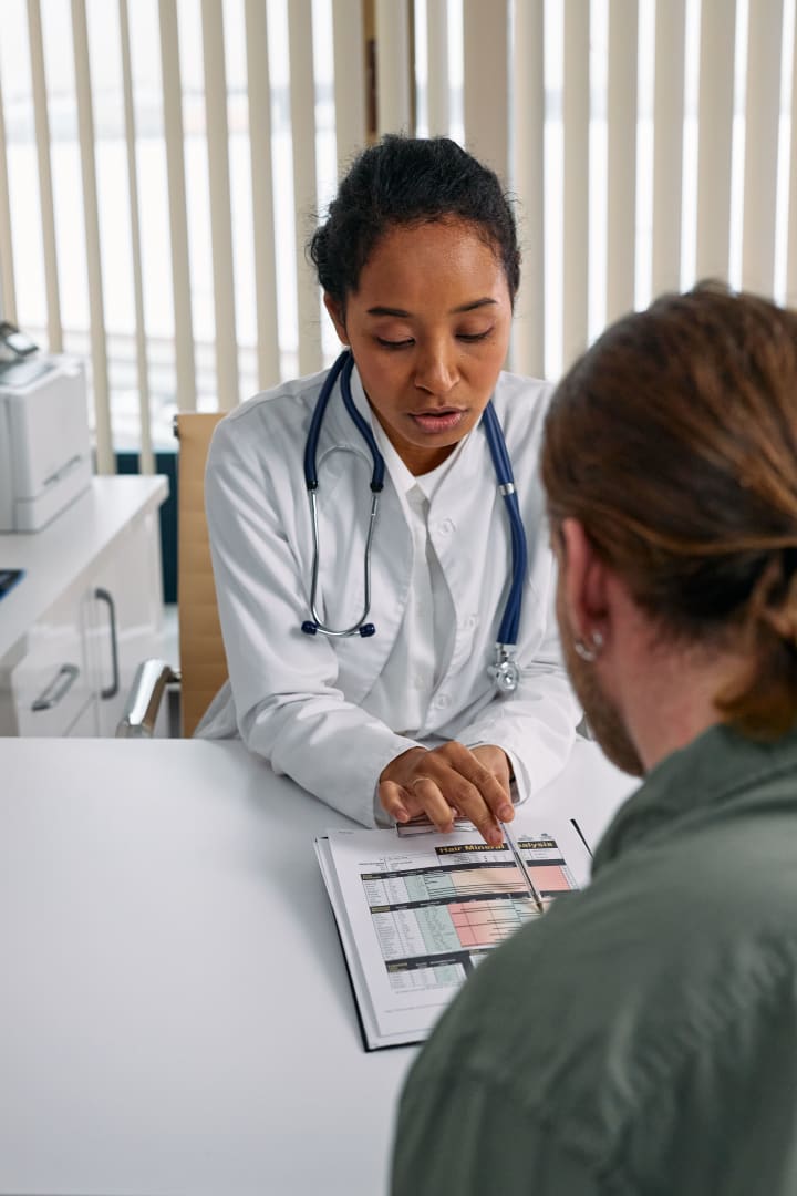 A clinician and patient review a document together during a professional consultation.