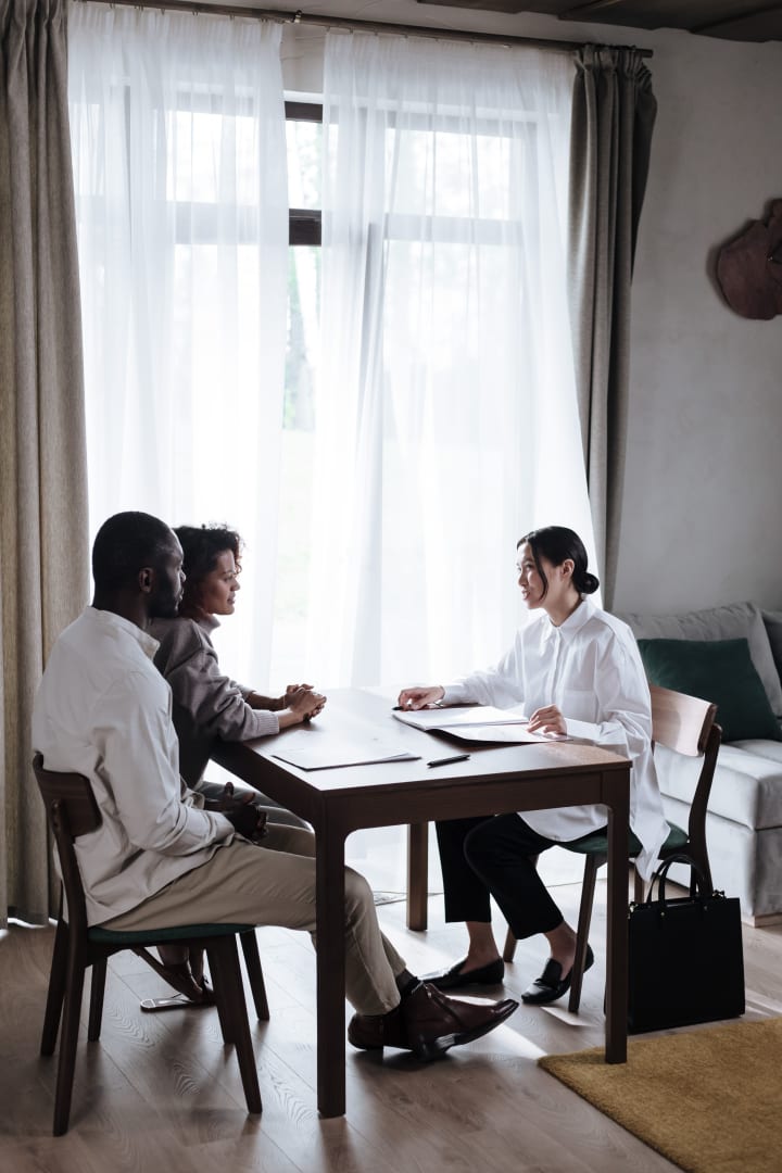 A diverse group discussing plans together in a bright office.