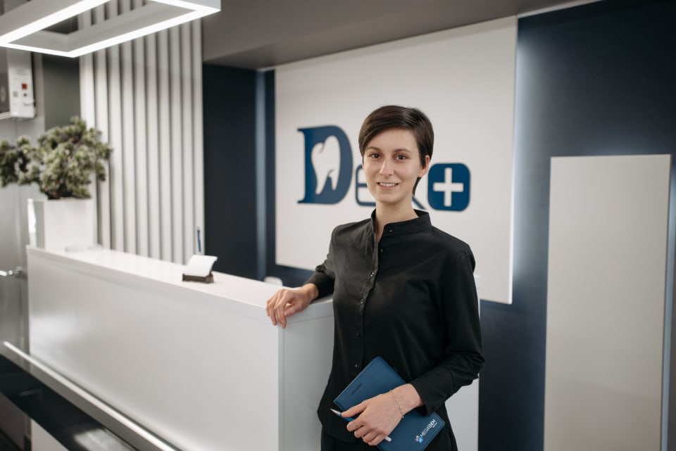 Receptionist working in a modern dental clinic lobby
