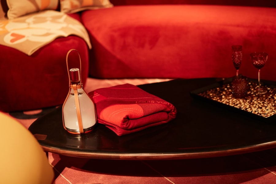 Red velvet sofa with Louis Vuitton crystal glassware and leather flask