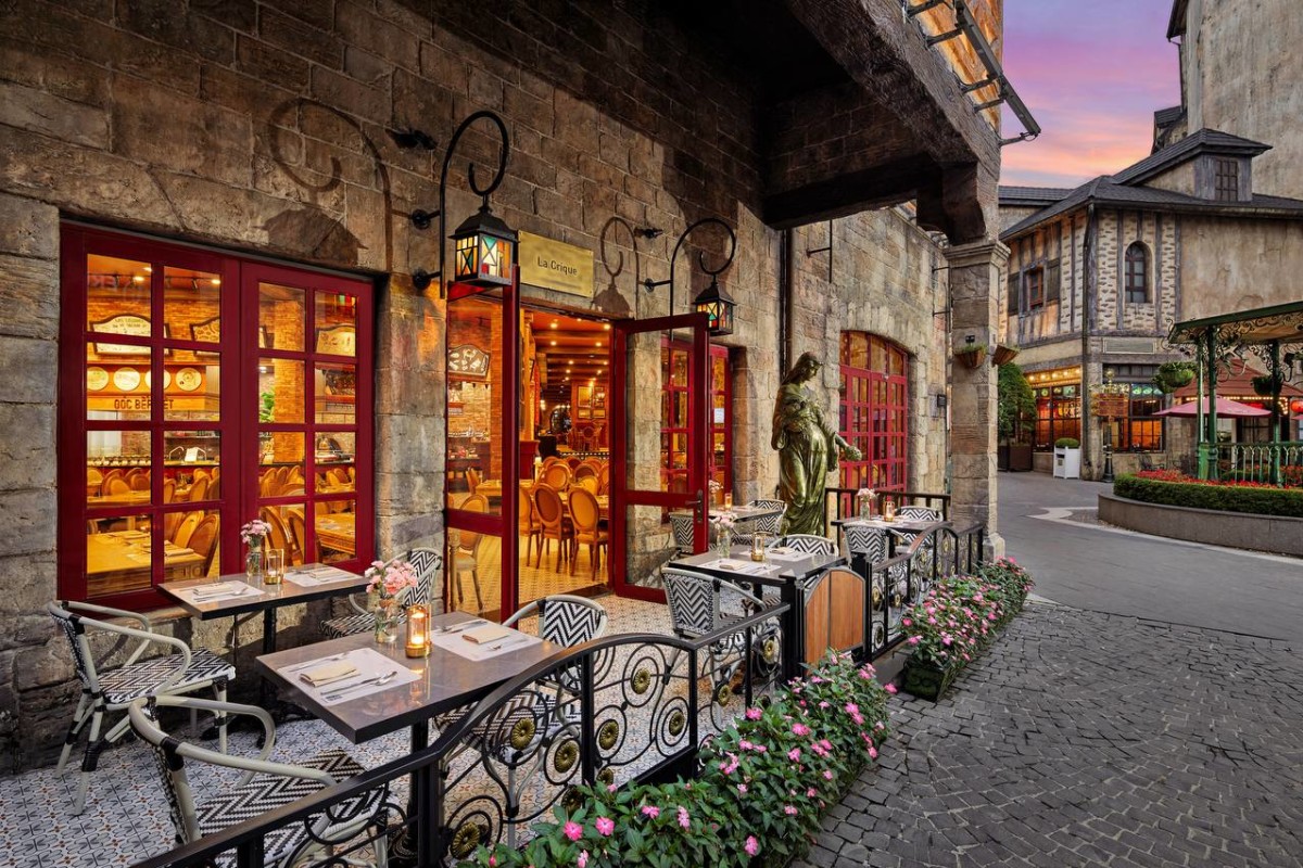 La Crique restaurant terrace at twilight with red doors and lanterns, Mercure Bana Hills