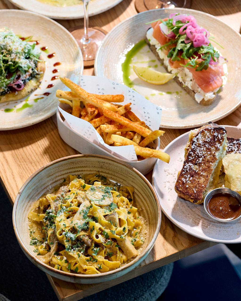 Lunch spread at Cafe Calton with mushroom pasta, smoked salmon toast, French toast with powdered sugar and fries