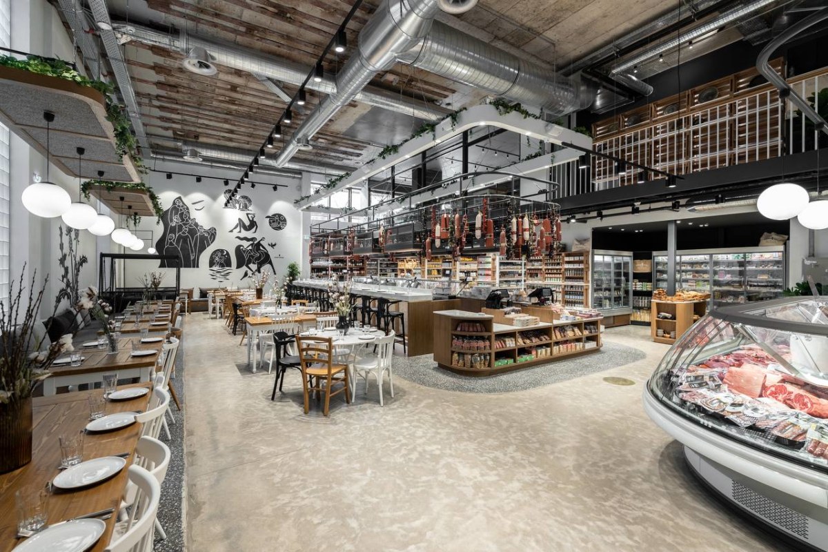 Restaurant interior at ERGON House Athens with wooden tables, globe pendant lights and bold graphic murals on white walls