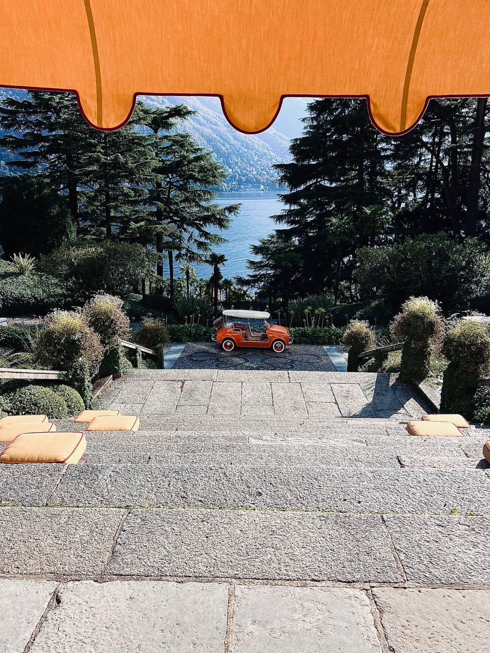 Steps down through orange awning to vintage Fiat Jolly at Passalacqua, Lake Como