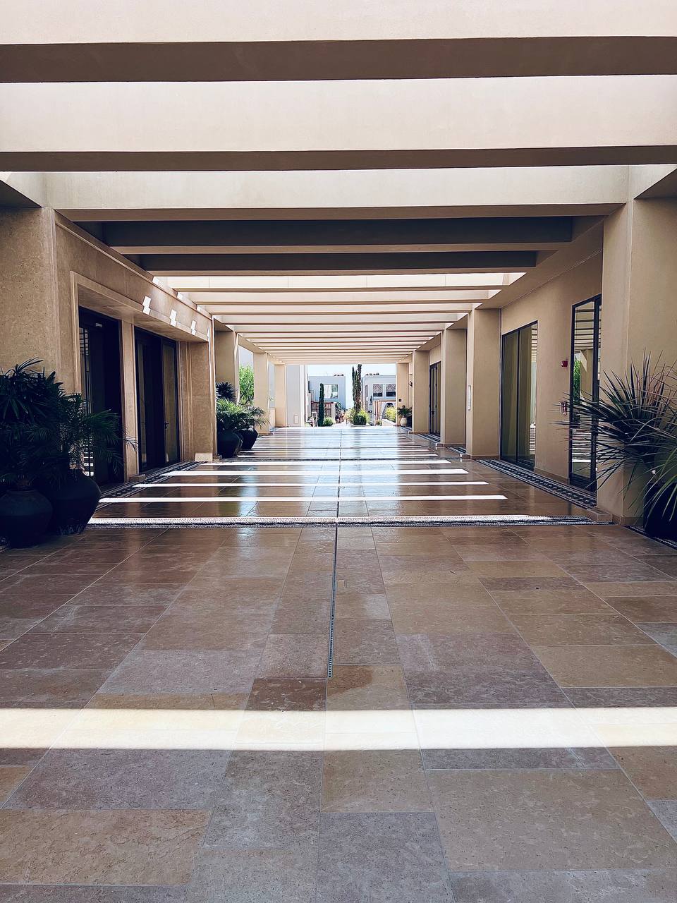 Architectural walkway with dramatic shadows leading to courtyard at Amoh Rhodes