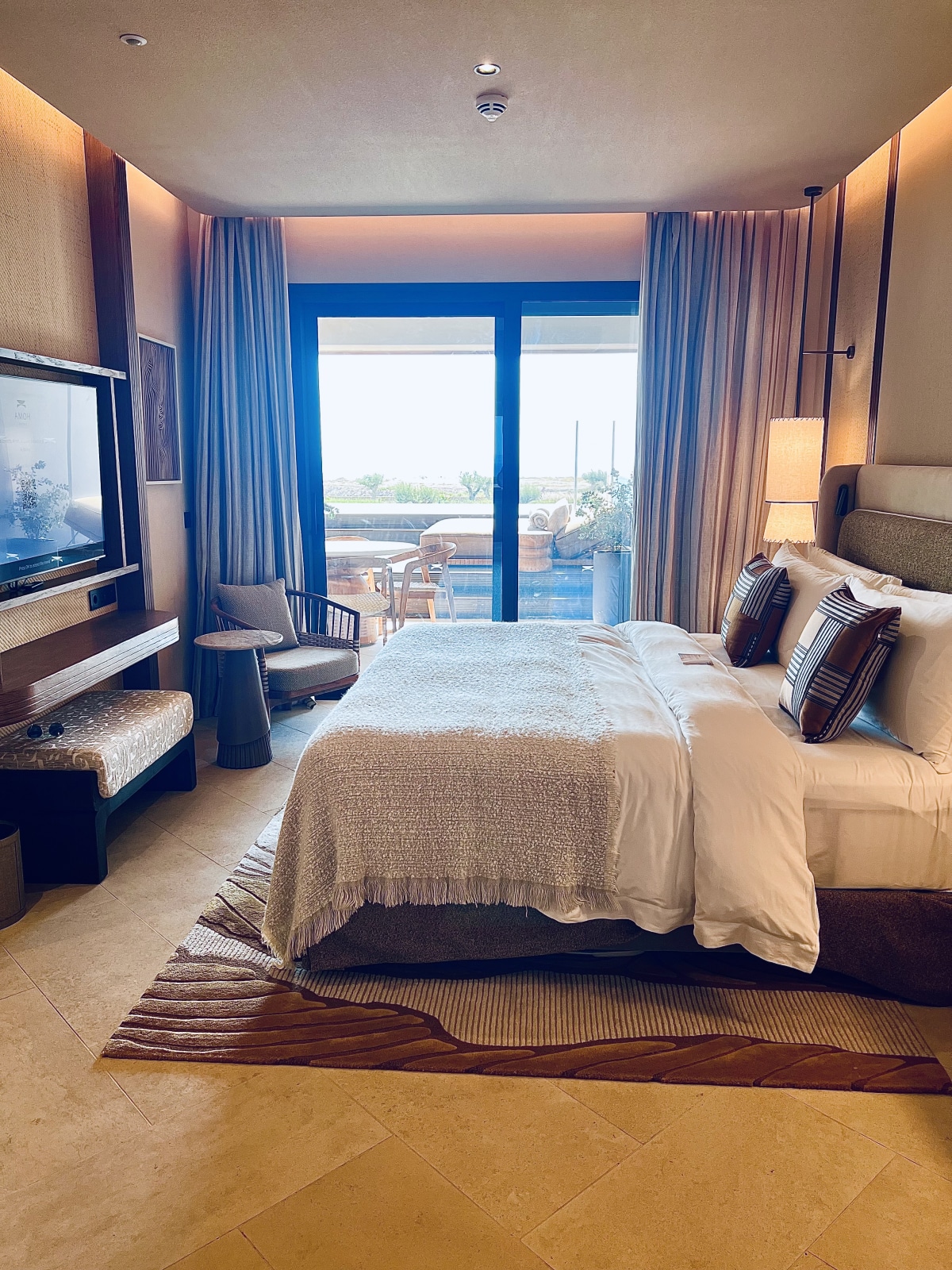 Selene Suite bedroom with floor-to-ceiling doors opening to a private balcony at Amoh