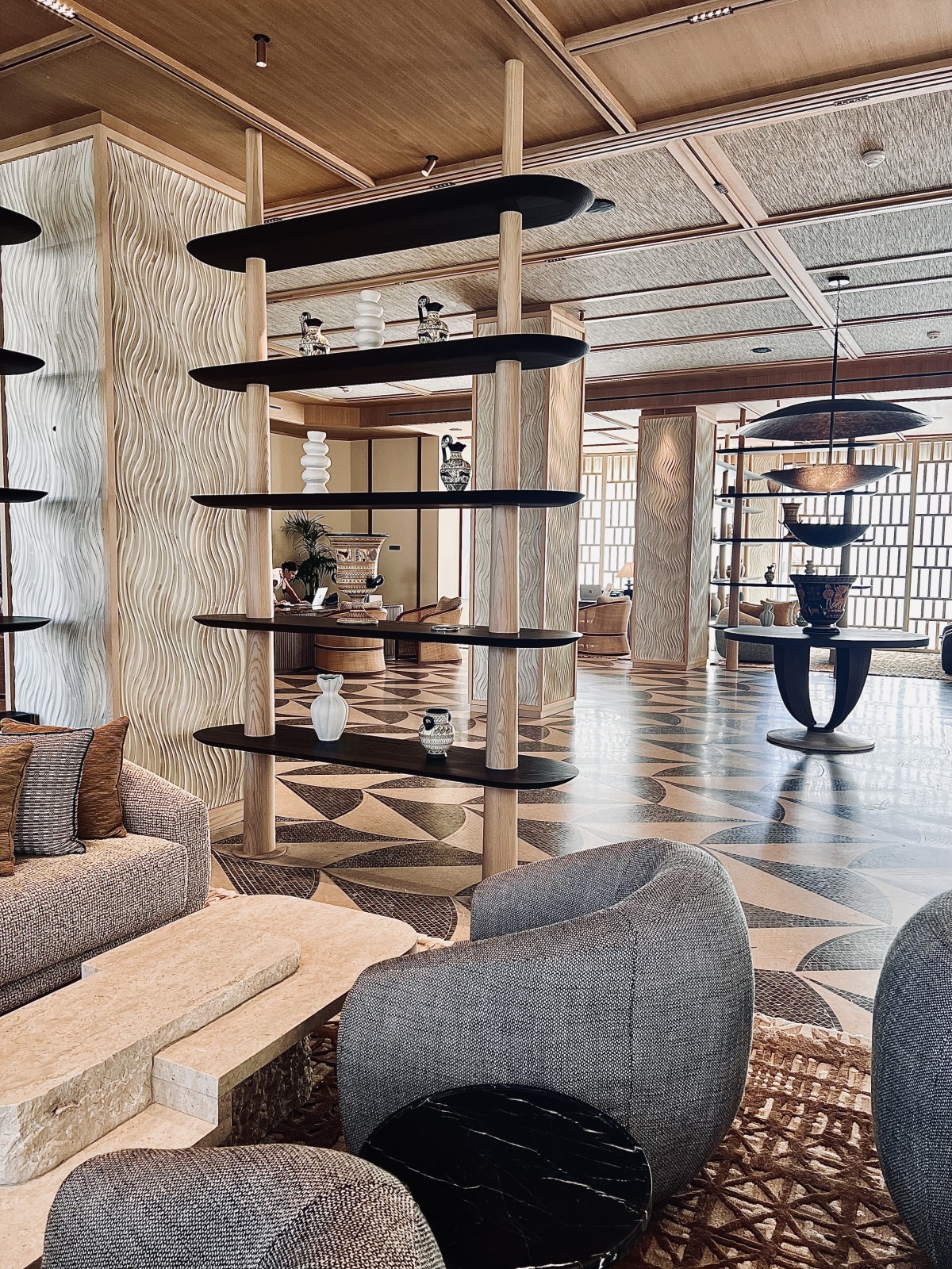 Amoh lobby with sculptural wooden shelving and patterned marble floors